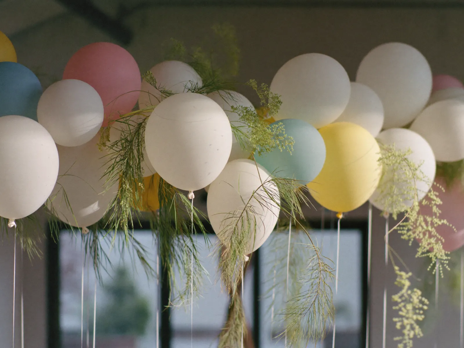 A balloon garland detail with greenery