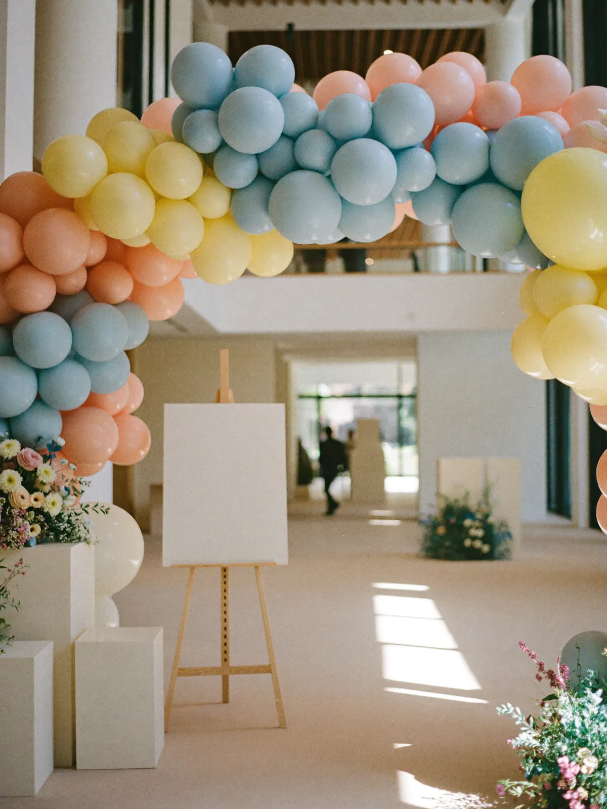 A venue entrance with a floral and balloon arch
