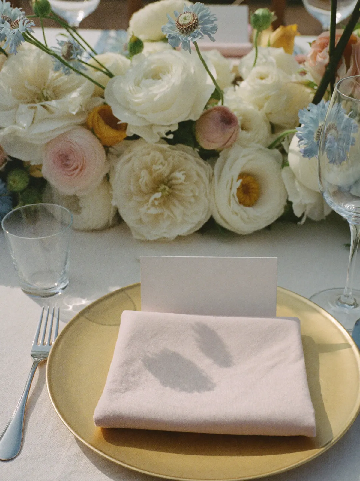A dressed place setting with florals and candles