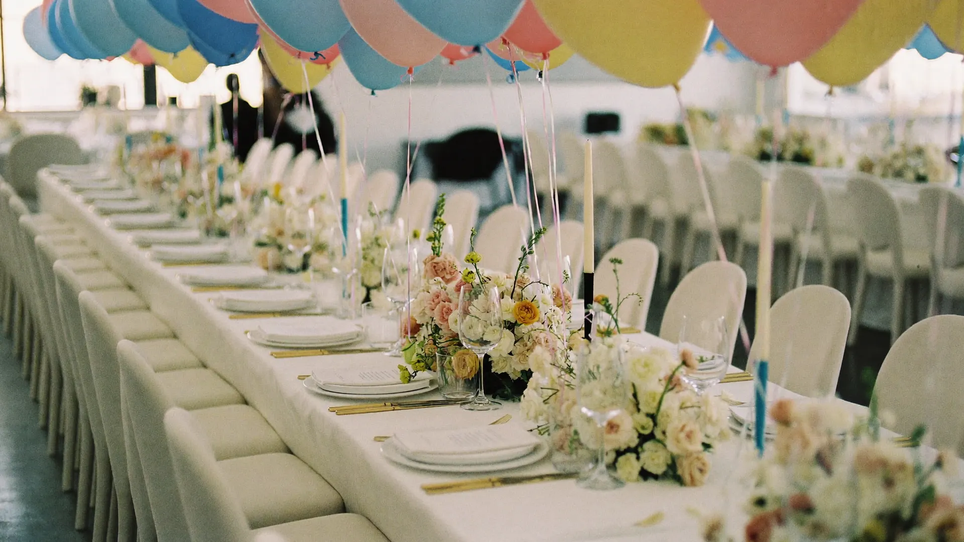 A long dinner table under a balloon garland