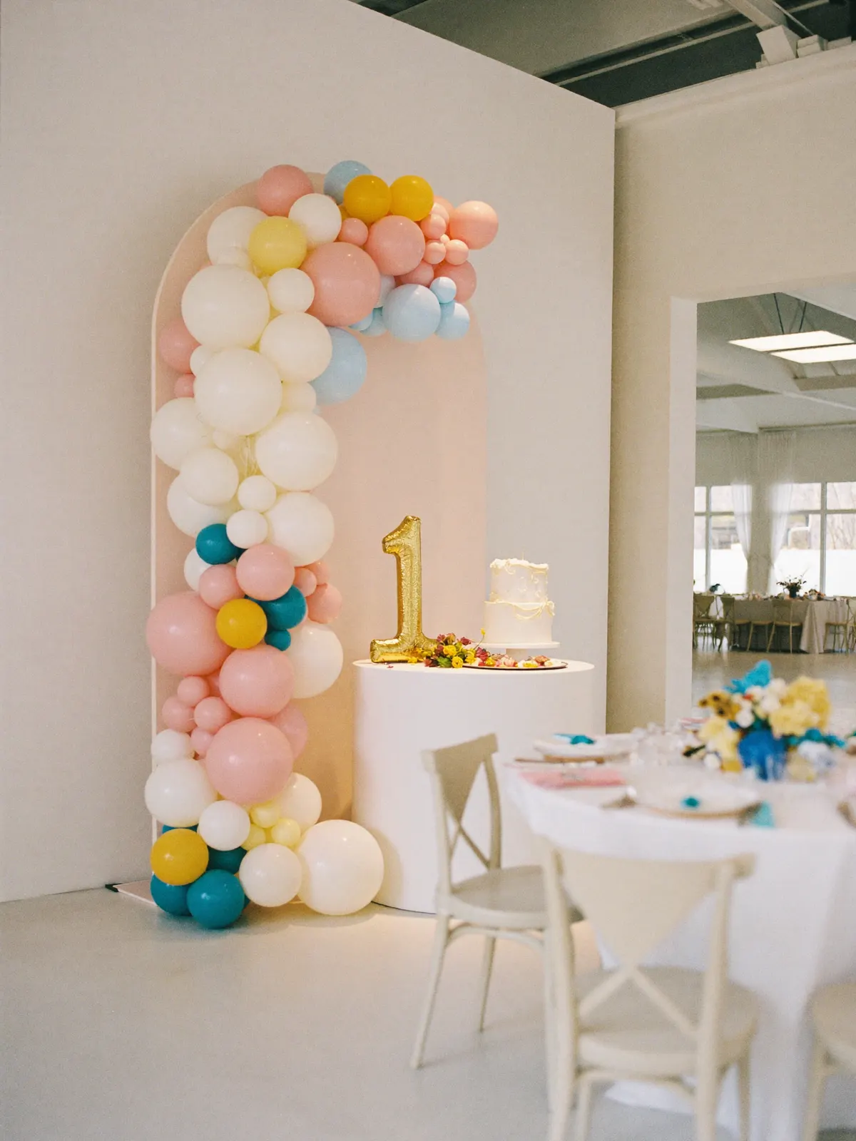 A birthday party setup with a backdrop and set tables